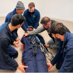 Equipo técnico de Altertec realizando una formación práctica en rescate y seguridad laboral con camilla y sistemas de sujeción en entorno de aula