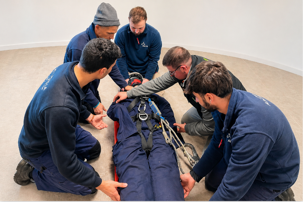 Equipo técnico de Altertec realizando una formación práctica en rescate y seguridad laboral con camilla y sistemas de sujeción en entorno de aula